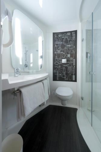 a bathroom with a sink and a toilet and a mirror at ibis Rouen Centre Champ de Mars in Rouen