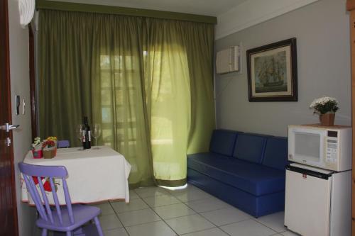 a living room with a blue couch and a table at Chalés Saint Germain in Florianópolis