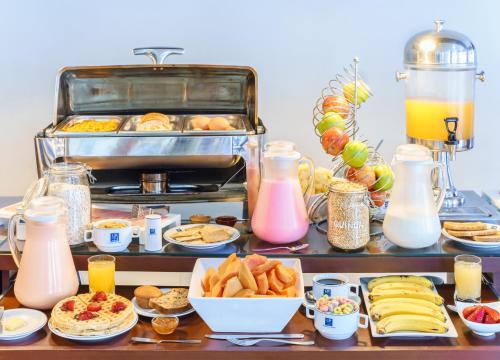 a buffet of breakfast foods and drinks on a table at Hotel LP Columbus in La Paz