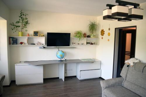 een bureau met een computer in een kamer bij Butterfly Apartment in Visaginas