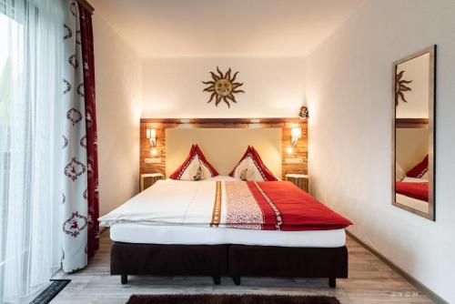 a bedroom with a bed with a red and white comforter at Appartementhaus Theresia in Bad Mitterndorf