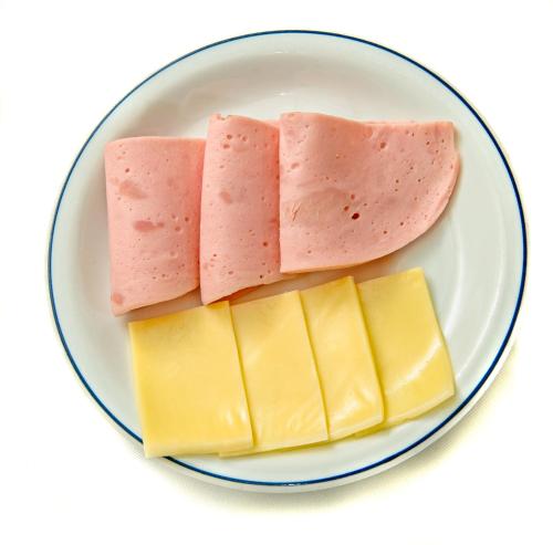 a plate of different types of cheese and meat at Hotel LP Columbus in La Paz