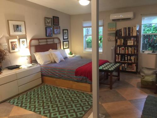 um quarto com uma cama, uma secretária e uma estante de livros em The Wild Rose em Miami