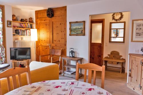 a living room with a couch and a tv at Chesa Alvra - Celerina in Celerina