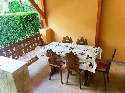 una mesa de comedor y sillas en una habitación con ventana en Apartman Marina, en Bük