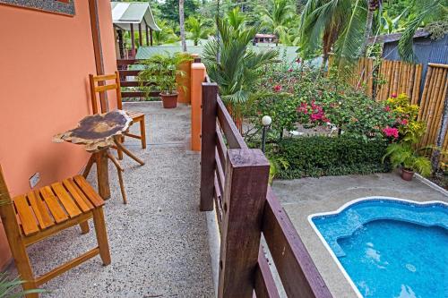 a backyard with a pool and a chair and a table at Inn On The Park in Manuel Antonio