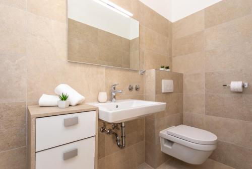 a bathroom with a sink and a toilet and a mirror at APARTMENTS HOUSE BARBARA 2 in Kornić