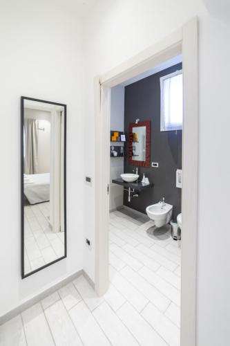 a bathroom with a mirror and a sink and a toilet at Anda e Rianda in Campi Bisenzio