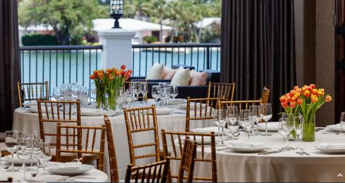 uma sala de jantar com mesas e cadeiras com flores em The Hotel Zamora em St. Pete Beach