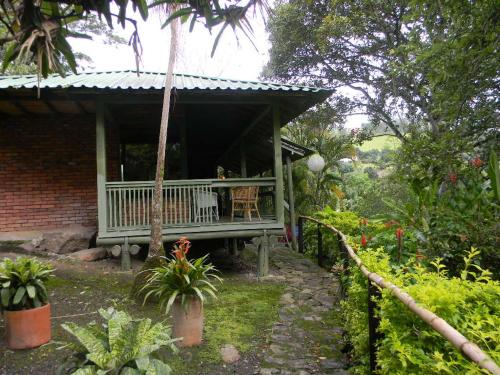 a porch of a house with a table and chairs at La Trini in Choachí