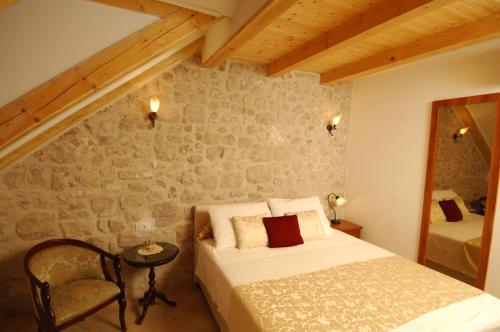 a bedroom with a bed and a table and a chair at Villa Sigurata in Dubrovnik
