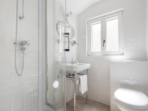 a white bathroom with a sink and a shower at The Byron in Dubrovnik