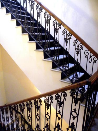 a staircase with black wrought iron railings at Albergo Birra in Savignone