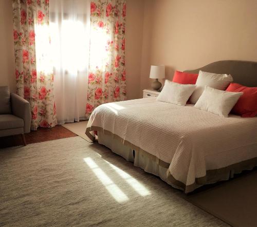 a bedroom with a bed with red pillows and a window at Villa Strelitzia Gran Canaria in Ingenio