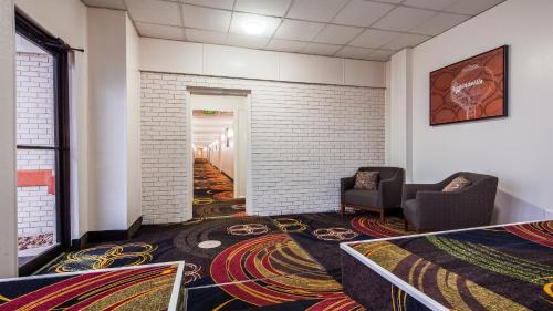a room with a hallway with chairs and carpet at SureStay Hotel by Best Western Higginsville in Higginsville