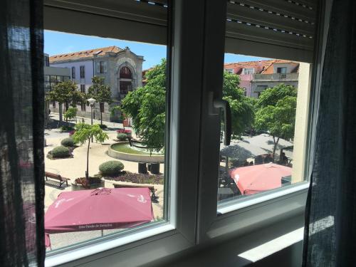 a view from a window of a courtyard with umbrellas at Eskama guest house in Esposende