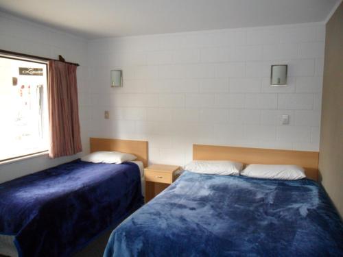 a hotel room with two beds and a window at Loredo Motel in Kaitaia