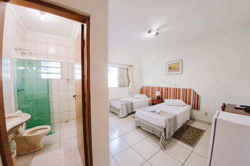 a bathroom with two beds and a shower at Hotel Passaledo in Indaiatuba