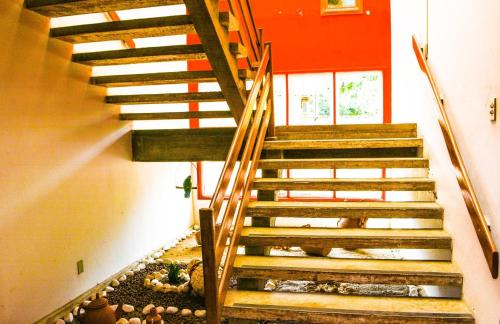 a staircase in a building with a red wall at Pousada Itaúnas in Conceição da Barra