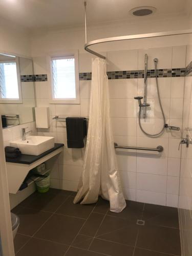 ein Bad mit einer Dusche und einem Waschbecken in der Unterkunft Rubicon Hotel Motel in Eildon