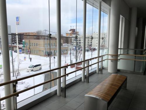 a balcony with a bench and a view of a city at Happy Apartment in Sapporo