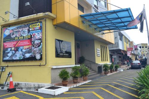 a yellow building with a sign on the side of a street at Hotel DarulMakmur Jerantut in Jerantut