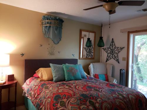 a bedroom with a colorful bed with two chairs at Grizzly Roadhouse Bed and Breakfast in Cortez