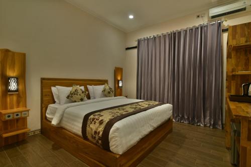 sypialnia z dużym łóżkiem i oknem w obiekcie Saka Boutique Hotel w mieście Nusa Penida