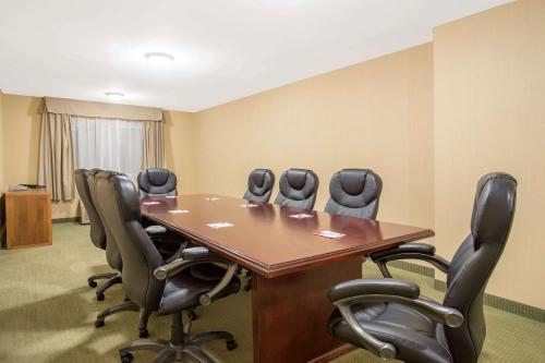 a conference room with a wooden table and chairs at Ramada by Wyndham Williams Lake in Williams Lake