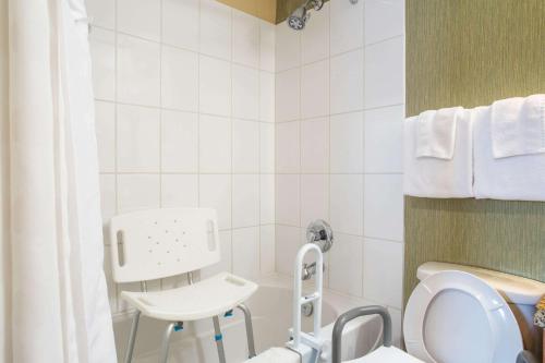 łazienka z toaletą i krzesłem w obiekcie Ramada by Wyndham Williams Lake w mieście Williams Lake