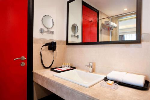 a bathroom with a sink and a mirror at Ramada Encore Jalandhar in Jalandhar