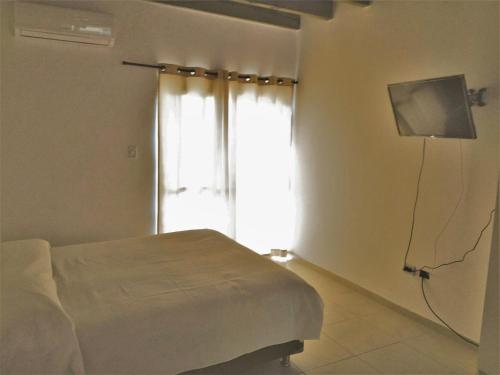 a bedroom with a bed and a television and a window at Departamento Andino del Sol in San Juan