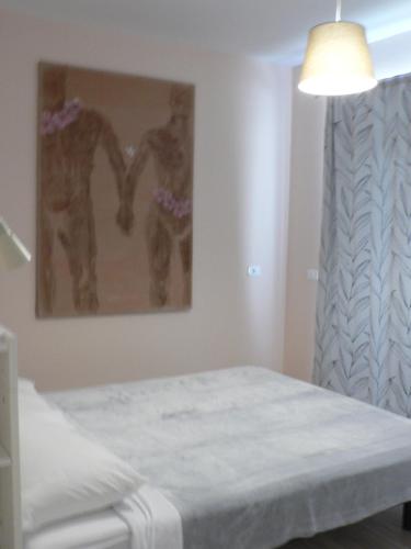 a bedroom with a bed and a painting on the wall at Apartments Hana in Pula