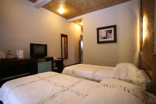 a hotel room with two beds and a television at Kampung Sumber Alam Garut in Garut