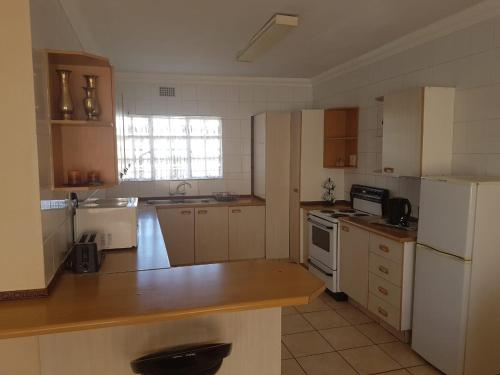 a kitchen with a white refrigerator and a stove at Queens Villa Guest House in Zeerust