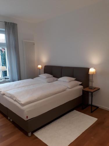 ジークマールシュツェルにあるAdlerhorst Suite Adults onlyのベッドルーム(ランプ2つ付)の大型ベッド1台