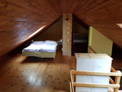 a attic room with a bed and a wooden ceiling at Apartman Aneta in Skalná