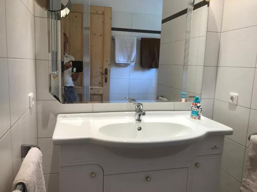 a bathroom with a white sink and a mirror at Ferienhaus Franz Eisl Radau 39 in St. Wolfgang