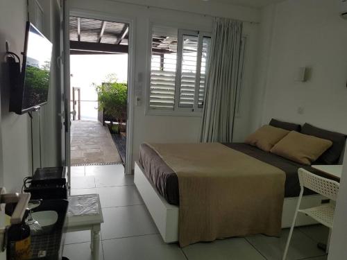 a bedroom with a bed and a door to a patio at Yialos Holiday Apartments in Pervolia