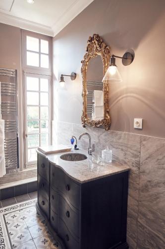 une salle de bain avec un lavabo et un miroir dans l'établissement Castel Bois Marie, Maison d'hôtes, à Montauban