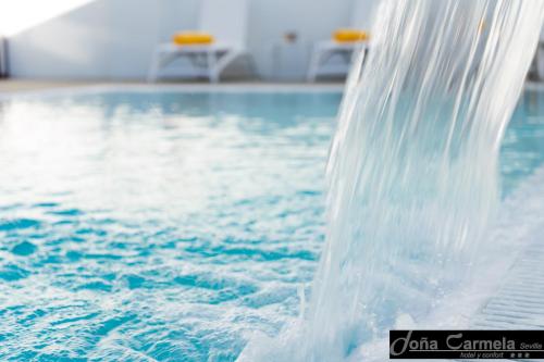 una fuente de agua en una piscina en Hotel Sercotel Doña Carmela, en Sevilla