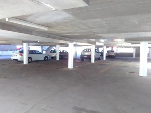 a parking garage with several cars parked in it at Palm Court Motor Inn in Port Macquarie