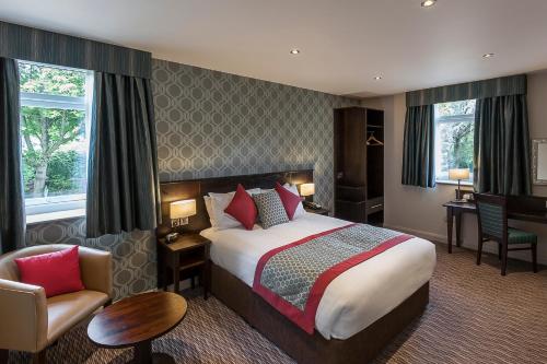 a hotel room with a bed and a chair at Best Western Plus Pinewood Manchester Airport-Wilmslow Hotel in Handforth