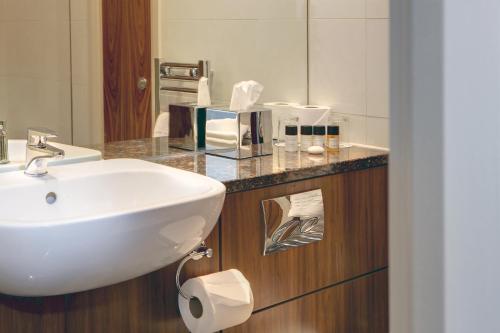 a bathroom with a sink and a mirror at Best Western Plus Pinewood Manchester Airport-Wilmslow Hotel in Handforth