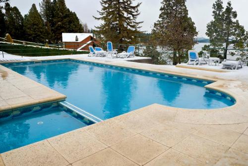 a large swimming pool with blue chairs at Charming Luxury Lodge & Private Spa in San Carlos de Bariloche