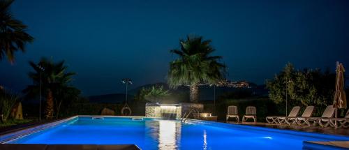a swimming pool in a resort at night at B&B Le Foglie D'Argento in Caltabellotta