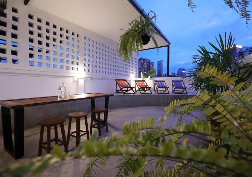 a rooftop patio with a table and chairs on a building at Apartment45 Hostel in Bangkok