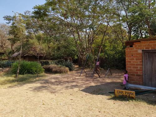 a man and a child playing on a playground at Tiko Community Centre in Saint Francis