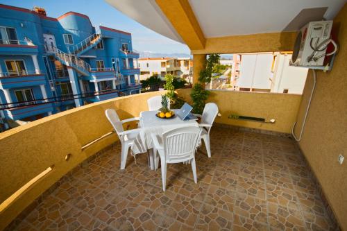 a balcony with a table and chairs and a building at Apartments Dalila in Ulcinj