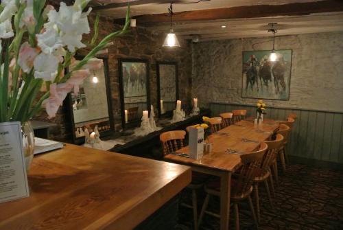 a restaurant with a long table with chairs and flowers at The Horse & Jockey Inn in Knighton